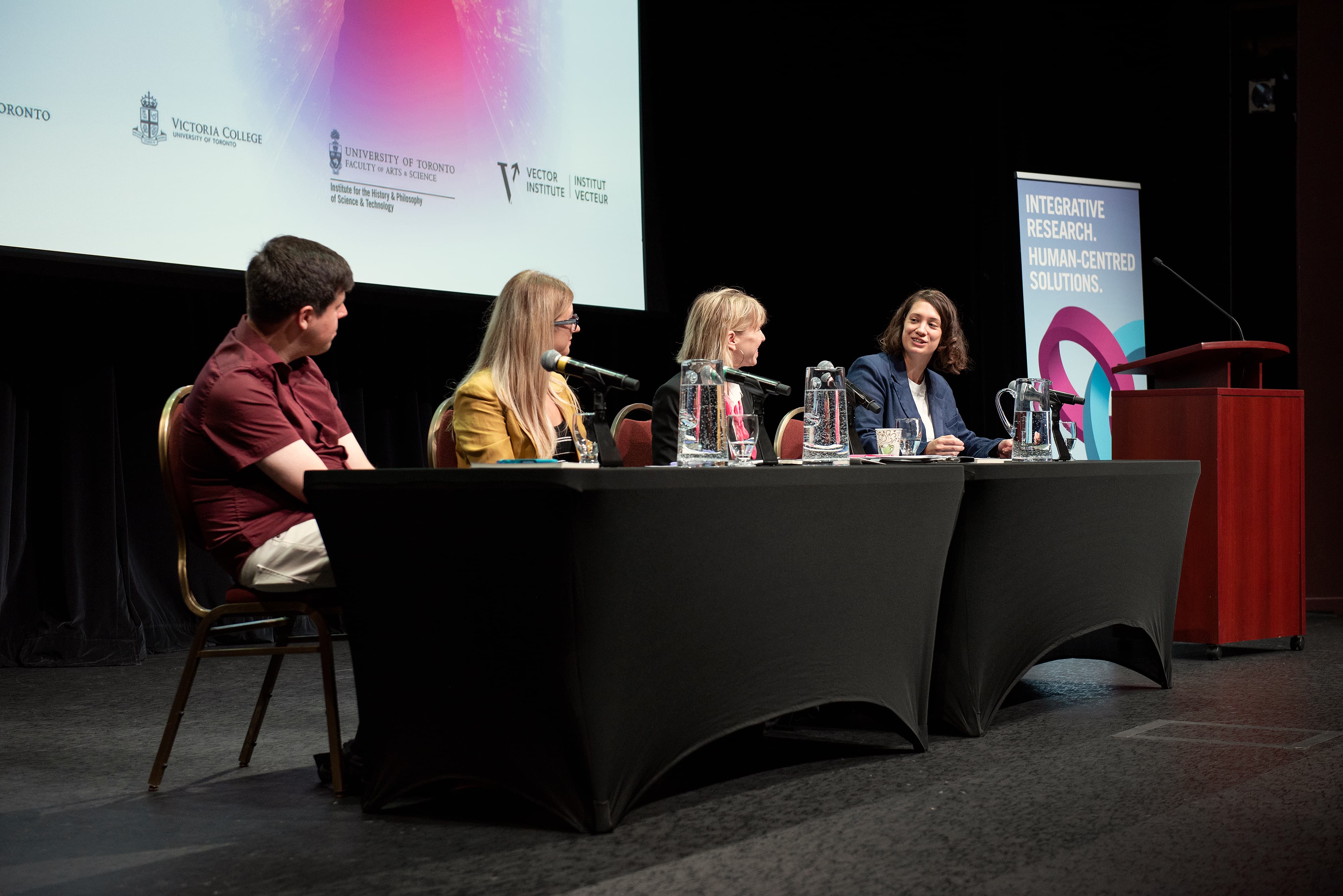 Karina Vold talking to the rest of the panel while they listen to her attentively