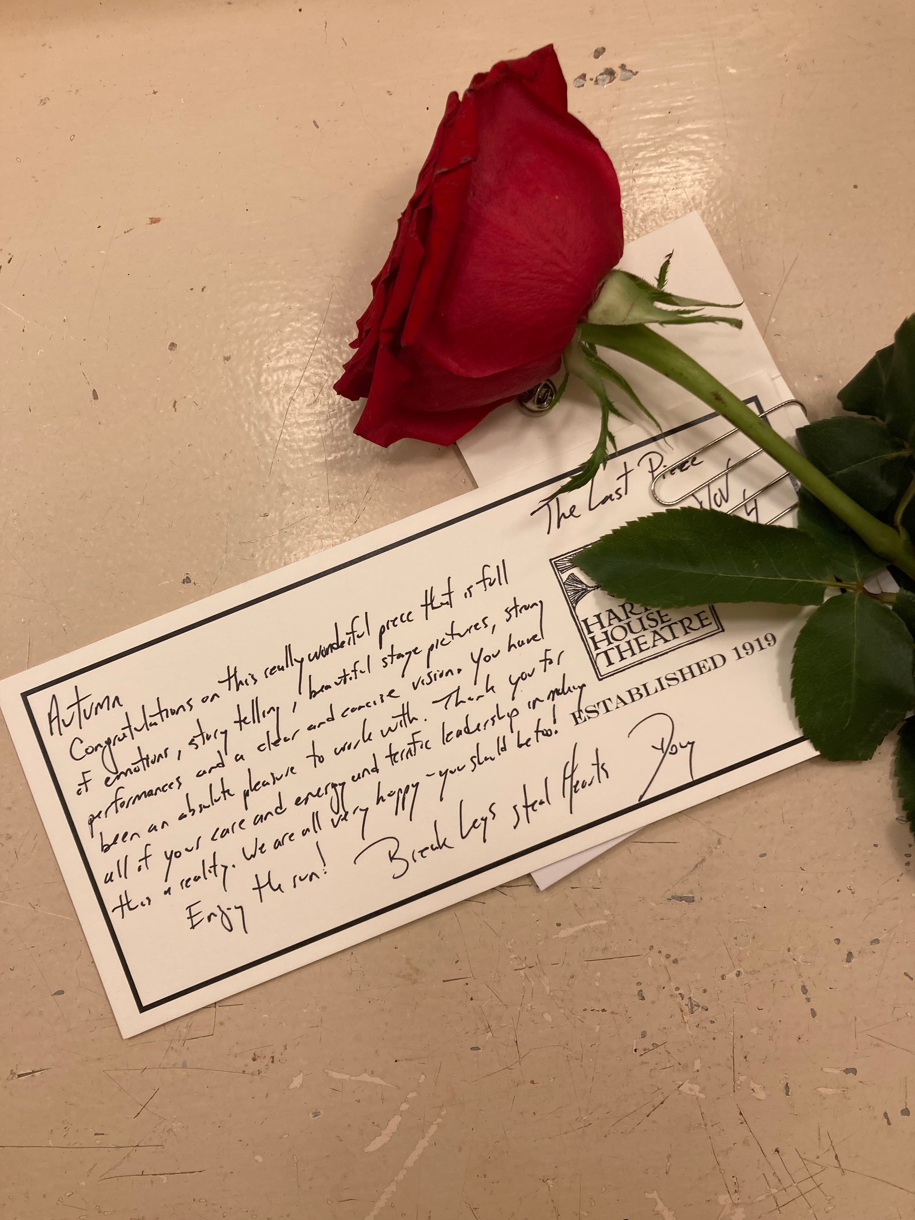 Handwritten note and a red rose on top